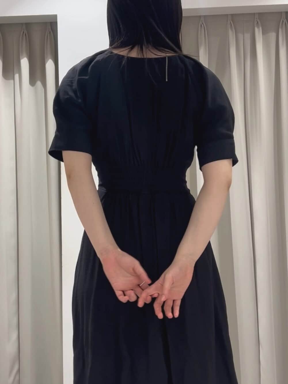 ホワイト系のサンダル、ブラック系のワンピースを着用したレディースの春コーディネートの6枚目の写真