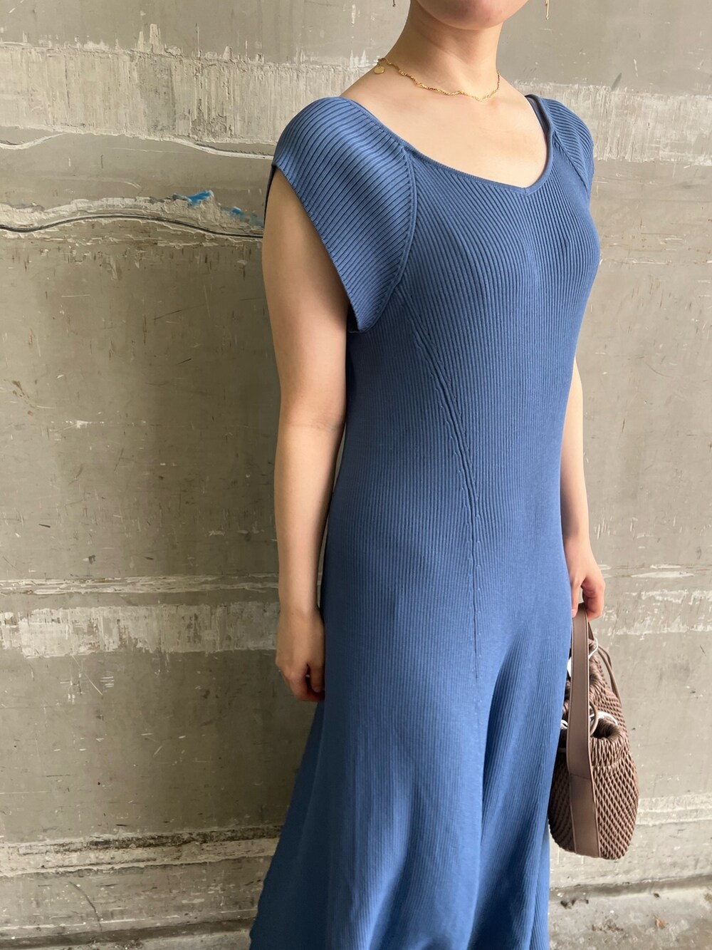 ホワイト系のハンドバッグ、ブルー系のワンピース、ベージュ系のサンダルを着用したレディースの夏コーディネートの3枚目の写真