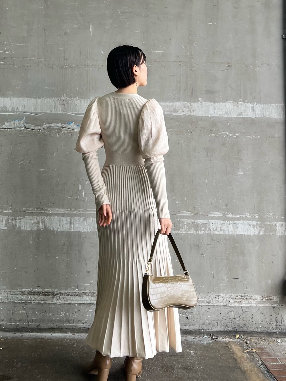 ベージュ系のブーツ、ホワイト系のワンピース、ベージュ系のハンドバッグを着用したレディースの冬コーディネートの2枚目の写真