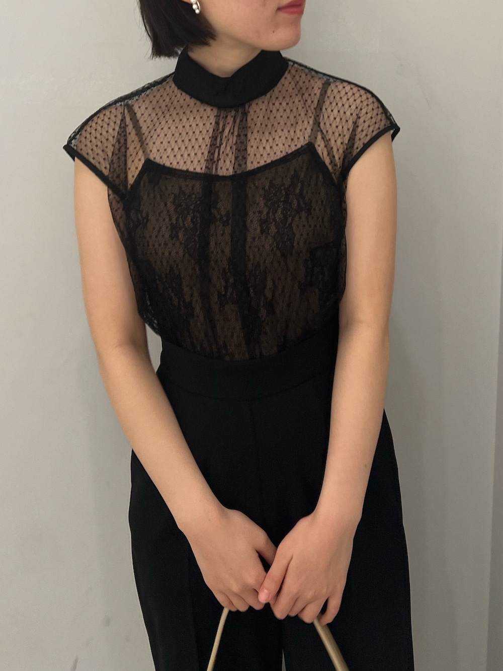 ベージュ系のパンプス、ブラック系のパンツドレス、ベージュ系のハンドバッグを着用したレディースの春コーディネートの4枚目の写真