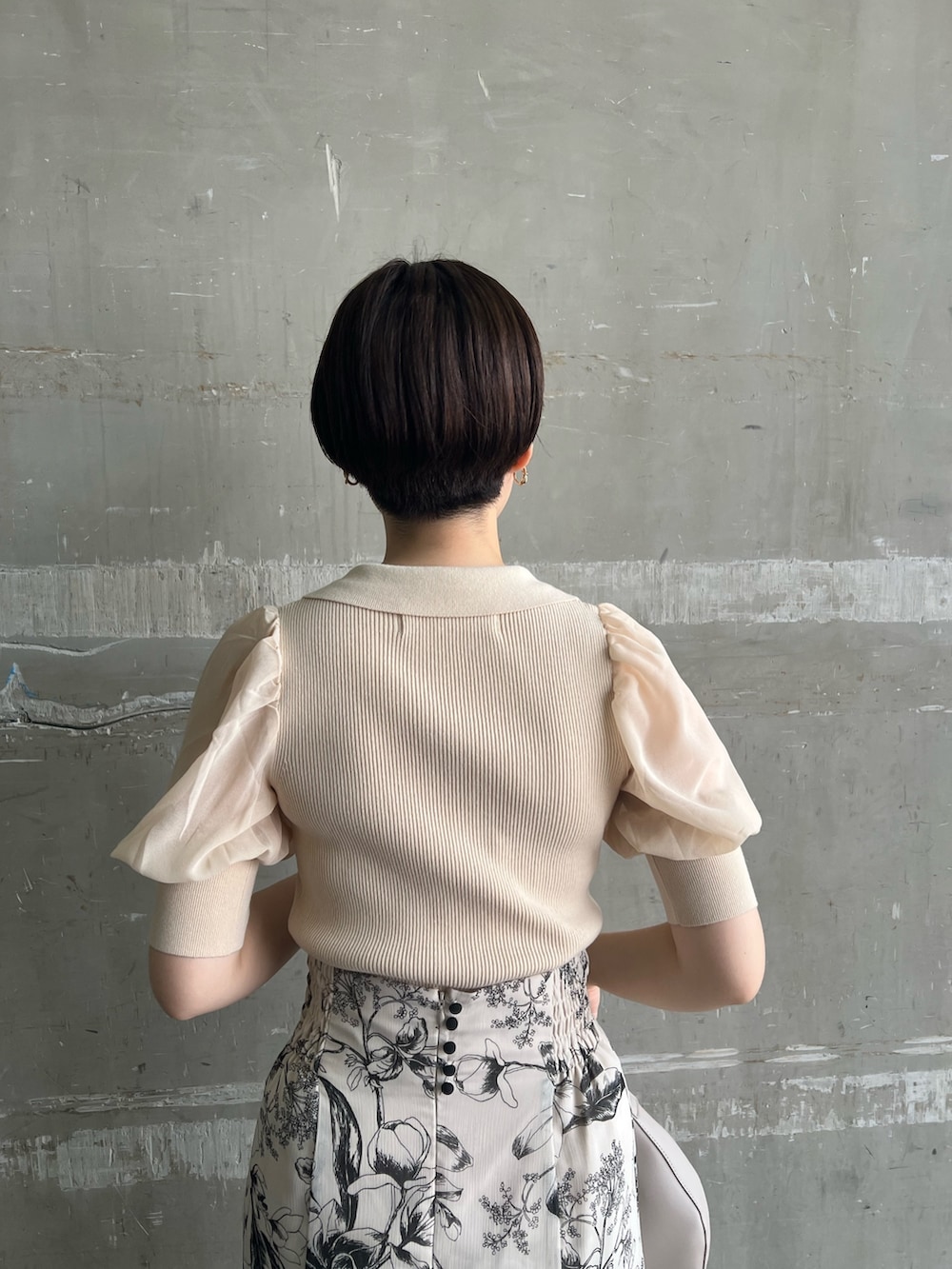 ホワイト系のニット/セーター、ホワイト系のスカート、ベージュ系のサンダルを着用したレディースの夏コーディネートの6枚目の写真