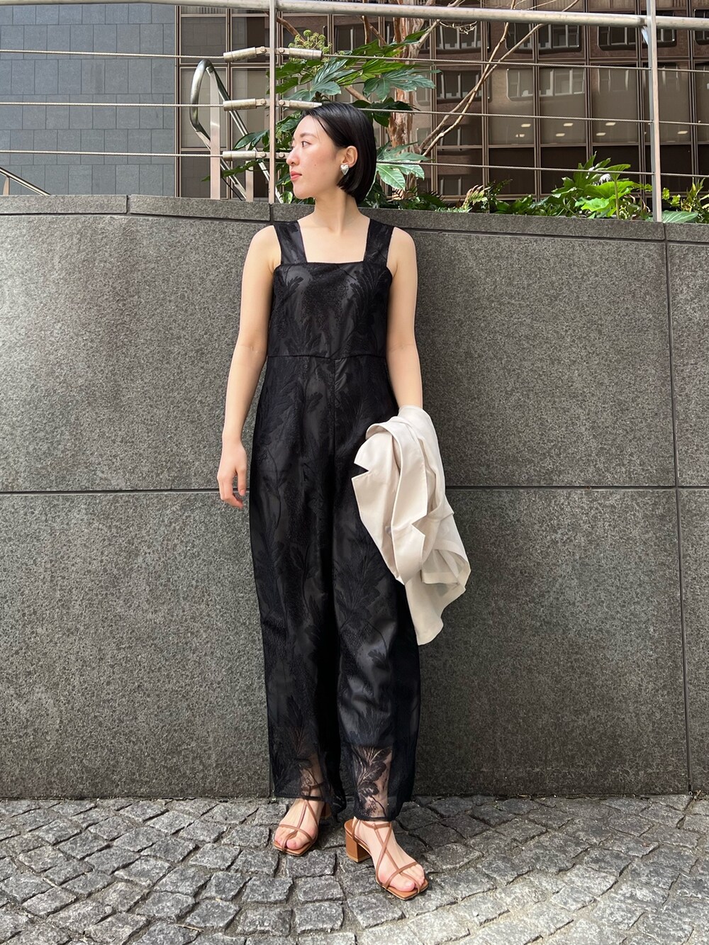 イエロー系のサンダル、ホワイト系のテーラードジャケット、ブラック系のつなぎ/オールインワンを着用したレディースの春コーディネートの5枚目の写真