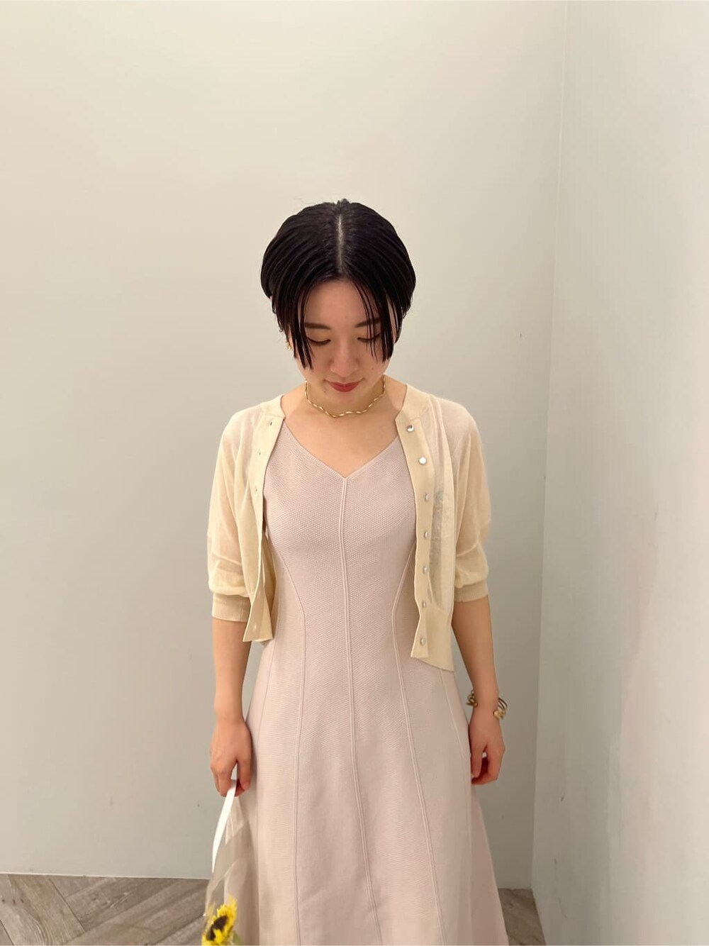 グリーン系のサンダル、ベージュ系のワンピース、ホワイト系のカーディガン/ボレロを着用したレディースの夏コーディネートの3枚目の写真