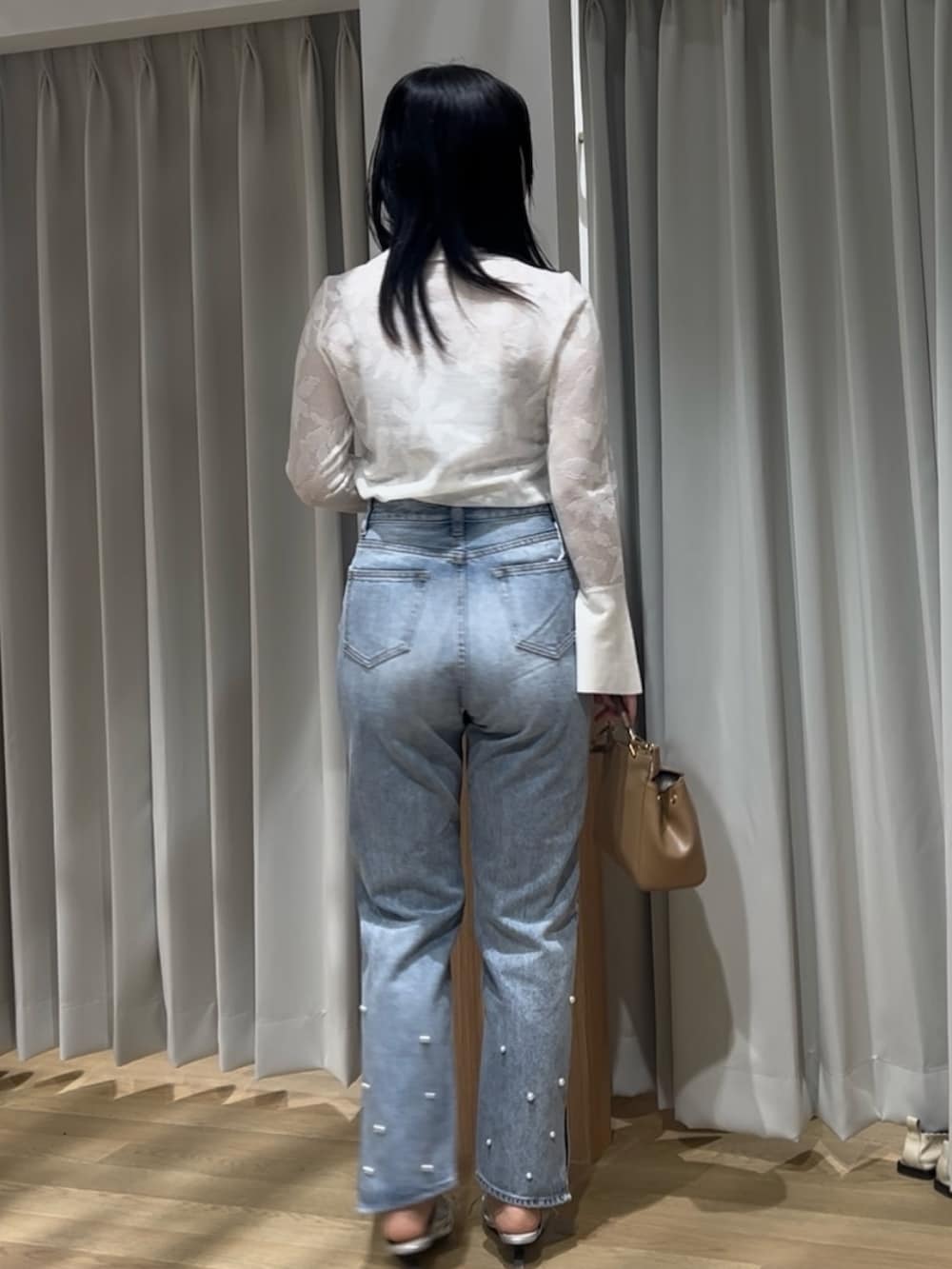 シルバー系のサンダル、ブルー系のデニムパンツ、ホワイト系のニット/セーターを着用したレディースの春コーディネートの3枚目の写真