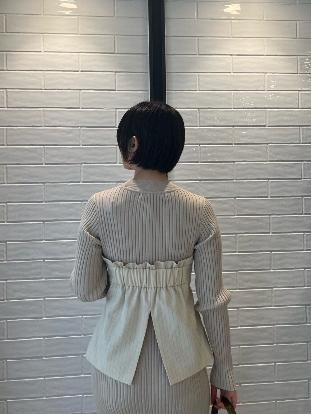 ベージュ系のブーツ、ベージュ系のワンピース、ブラウン系のショルダーバッグを着用したレディースの冬コーディネートの5枚目の写真