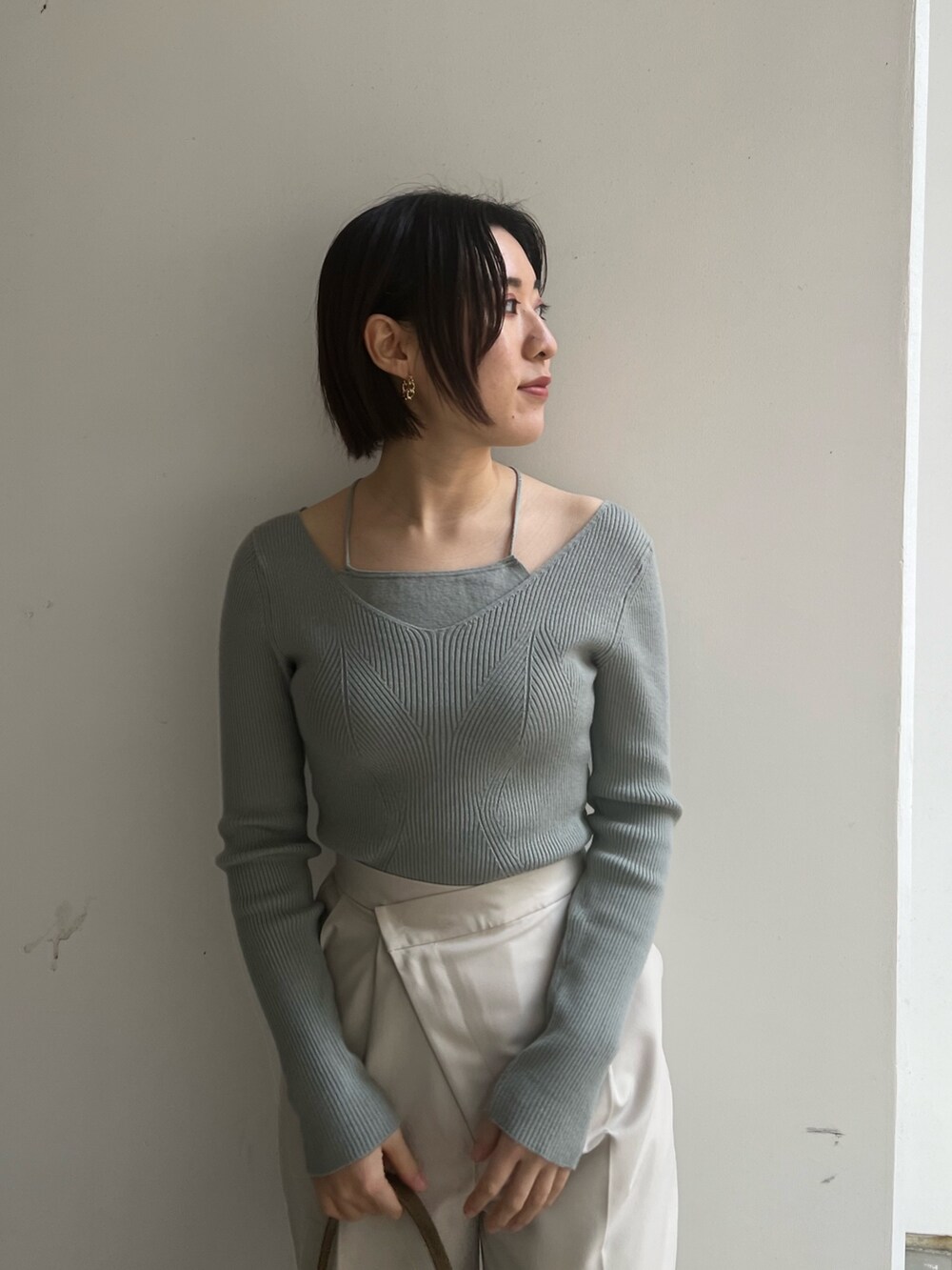 ベージュ系のブーツ、ホワイト系のスラックス、ホワイト系のニット/セーターを着用したレディースの冬コーディネートの3枚目の写真