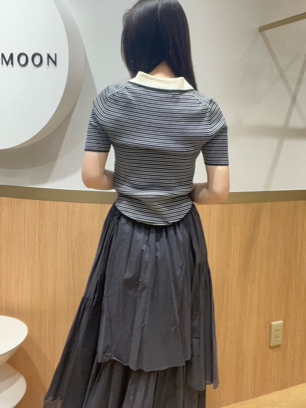 グレー系のスカート、その他のニット/セーター、ベージュ系のサンダルを着用したレディースの春コーディネートの6枚目の写真