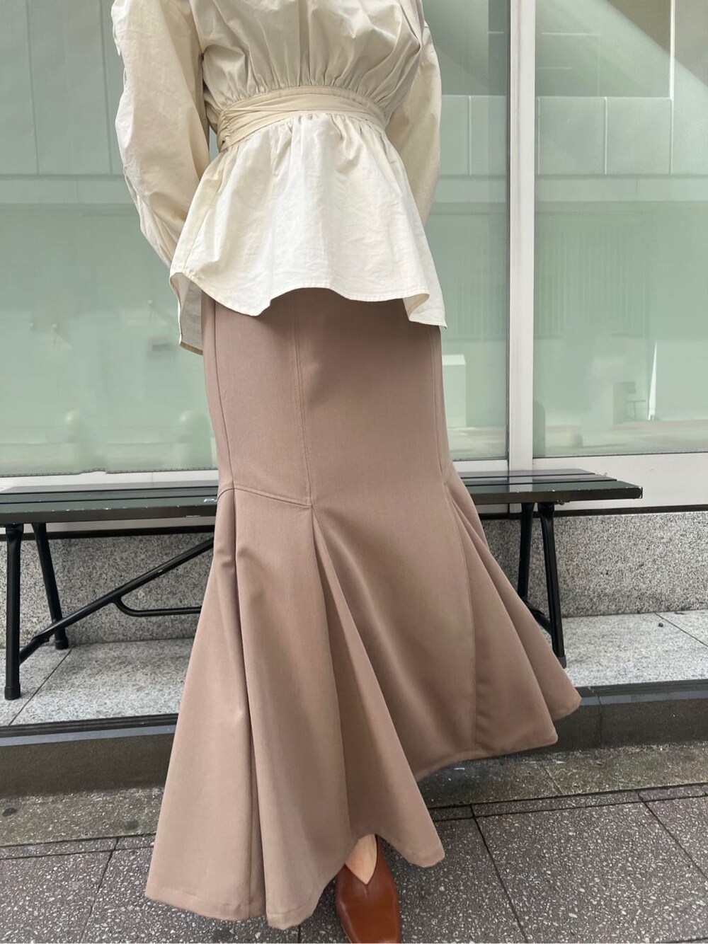 ベージュ系のスカート、ホワイト系のシャツ/ブラウス、ホワイト系のパンプスを着用したレディースの冬コーディネートの4枚目の写真