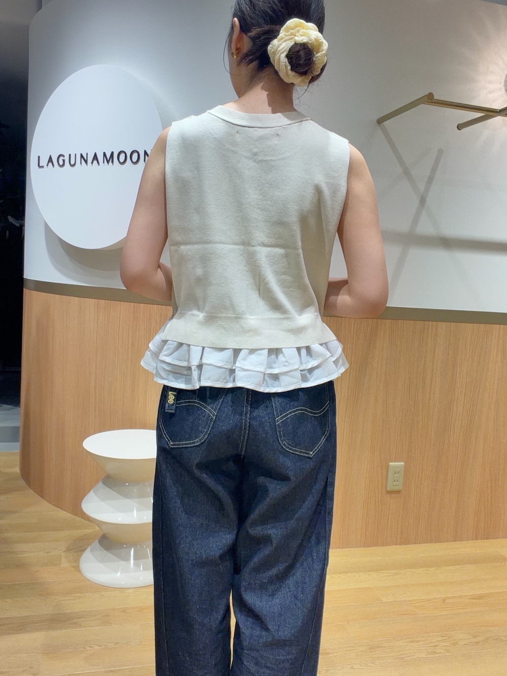 ホワイト系のニット/セーター、オレンジ系のサンダル、ブルー系のデニムパンツを着用したレディースの夏コーディネートの6枚目の写真