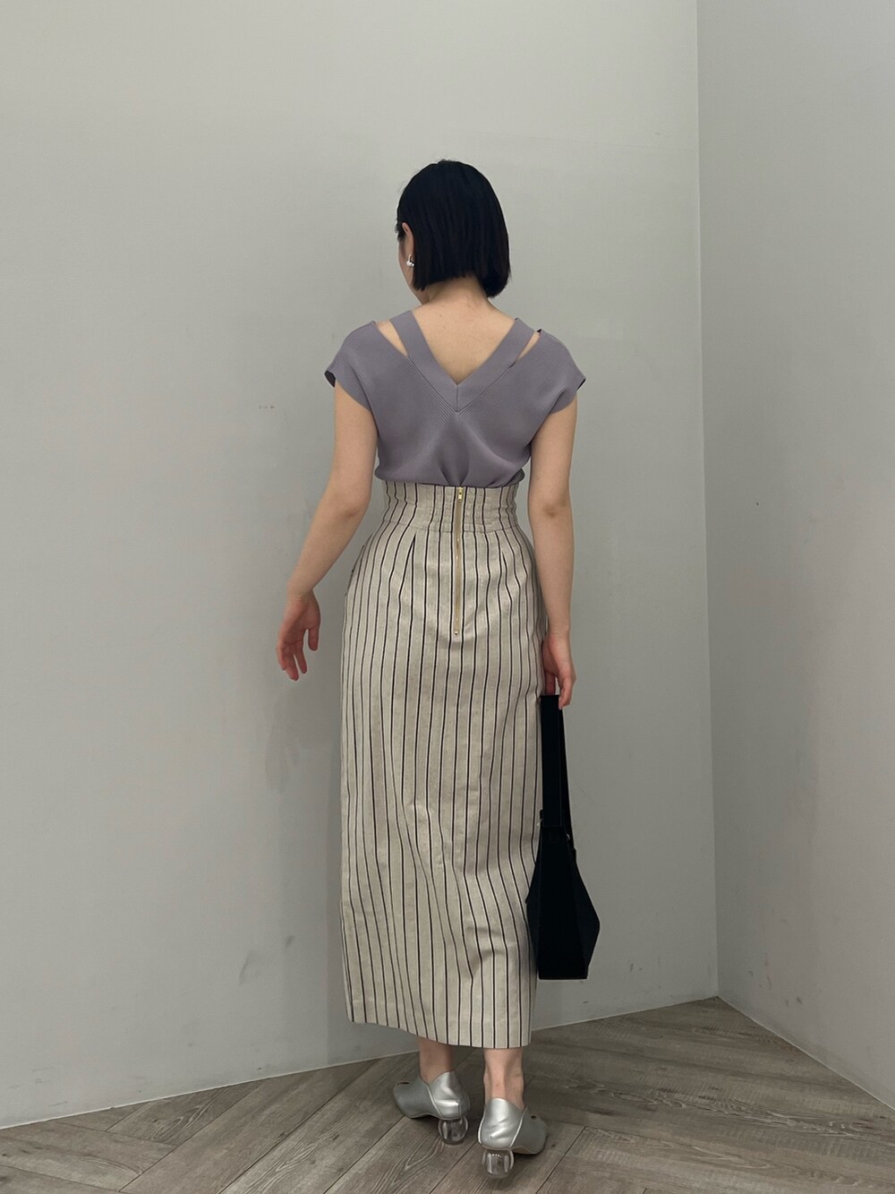 ブルー系のニット/セーター、シルバー系のパンプス、グレー系のスカートを着用したレディースの春コーディネートの2枚目の写真