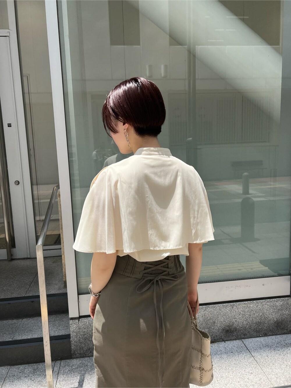 グリーン系のサンダル、ベージュ系のスカート、ホワイト系のショルダーバッグを着用したレディースの夏コーディネートの7枚目の写真