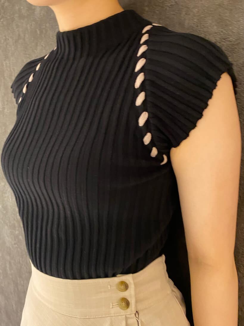 ブラウン系のパンプス、ホワイト系のスカート、ブラック系のニット/セーターを着用したレディースの夏コーディネートの2枚目の写真