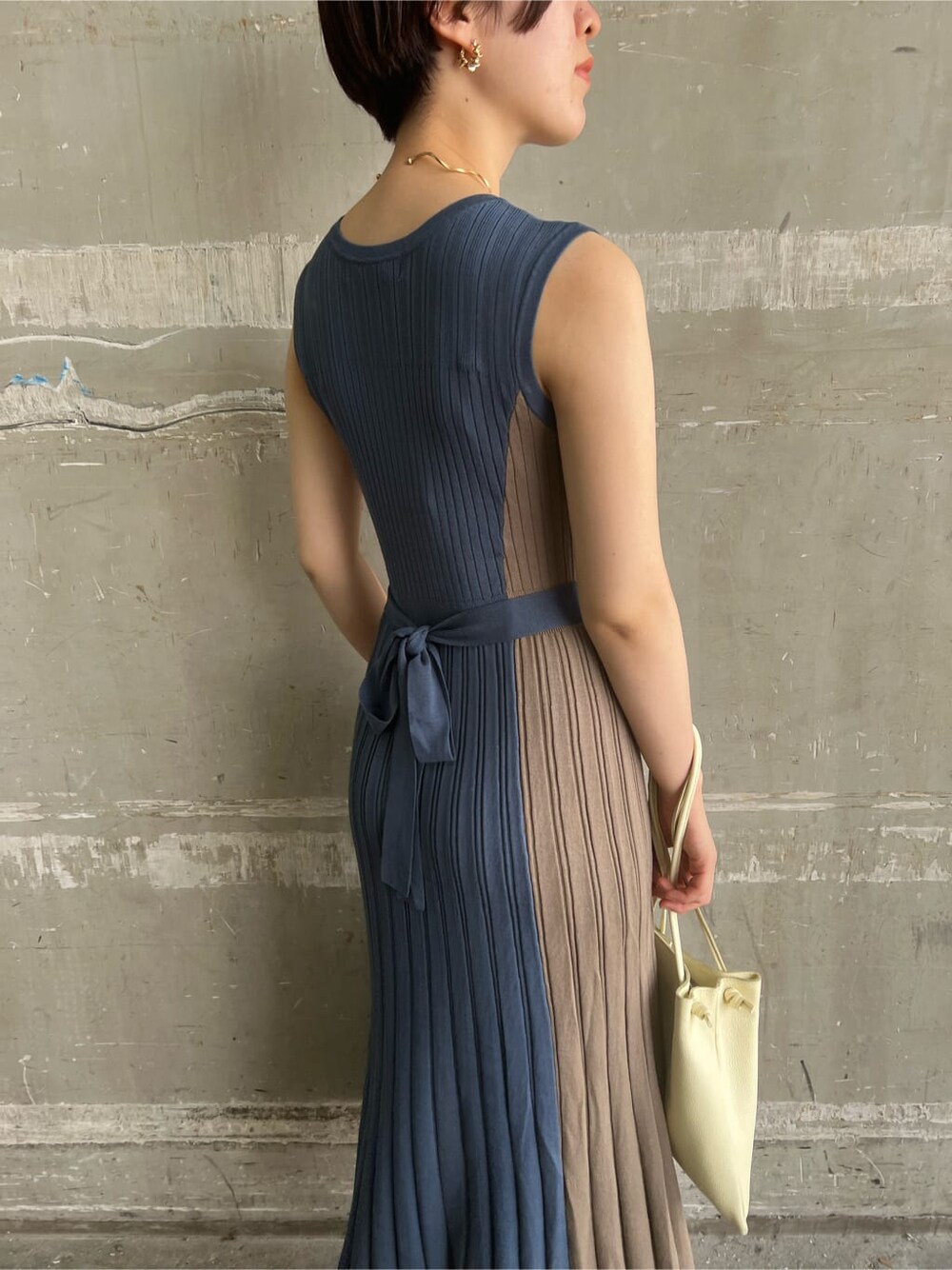 ホワイト系のハンドバッグ、ブルー系のワンピース、ゴールド系のピアス（両耳用）を着用したレディースの夏コーディネートの7枚目の写真