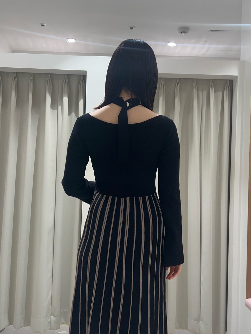 ブラック系のワンピース、ブラック系のブーツを着用したレディースの秋コーディネートの6枚目の写真