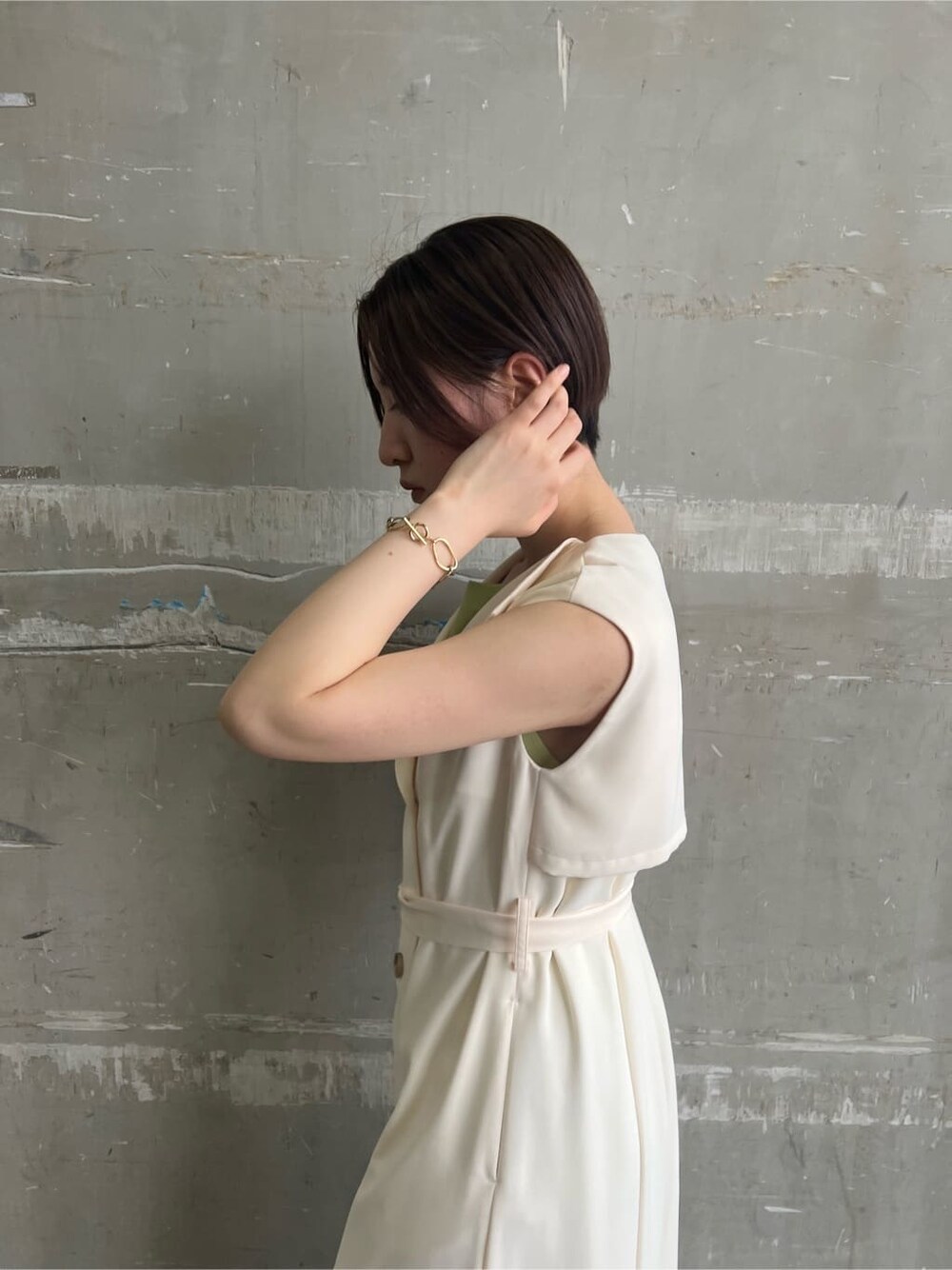 ホワイト系のハンドバッグ、ホワイト系のワンピース、グリーン系のサンダルを着用したレディースの春コーディネートの6枚目の写真