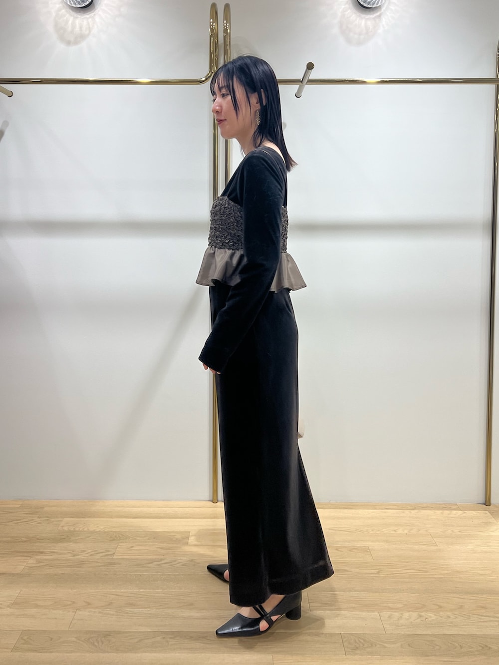 ブラック系のパンプス、ブラウン系のドレスを着用したレディースの冬コーディネートの2枚目の写真