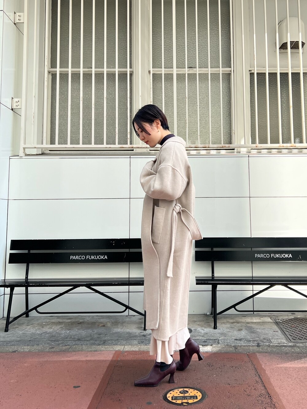 レッド系のブーツ、グレー系のスカート、グレー系のニット/セーターを着用したレディースの秋コーディネートの2枚目の写真