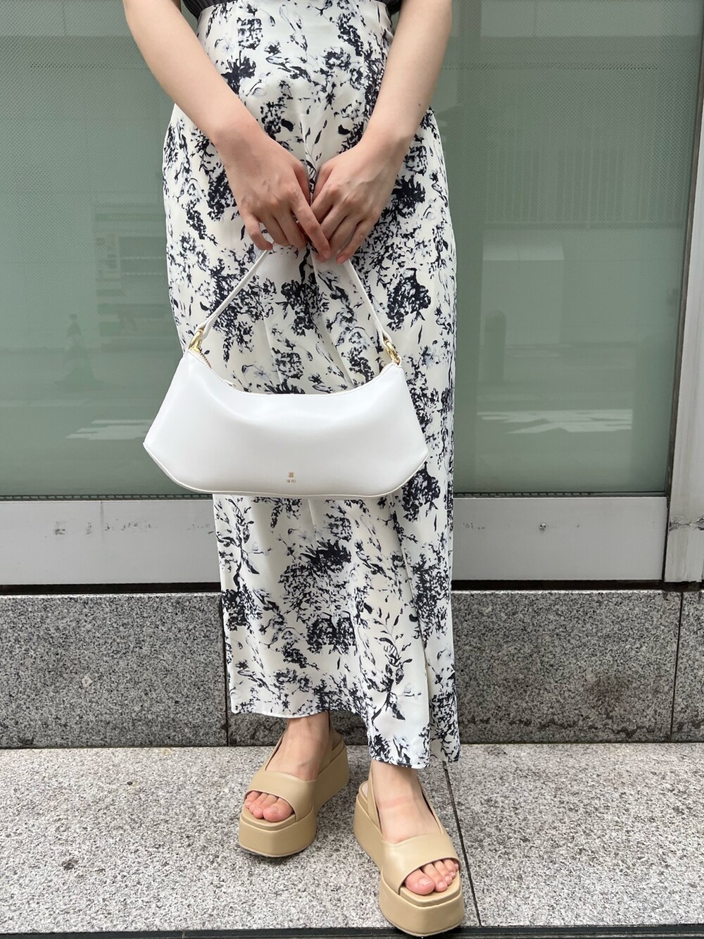 ベージュ系のサンダル、ブルー系のスカート、ホワイト系のハンドバッグを着用したレディースの夏コーディネートの6枚目の写真