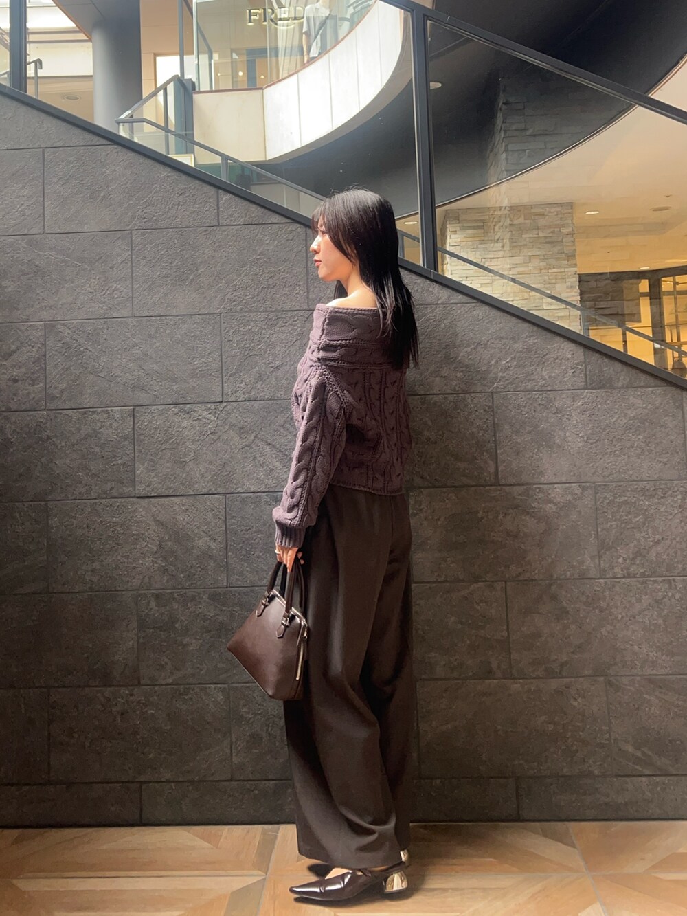 グレー系のニット/セーター、グレー系のその他パンツ、ブラウン系のパンプスを着用したレディースの秋コーディネートの2枚目の写真