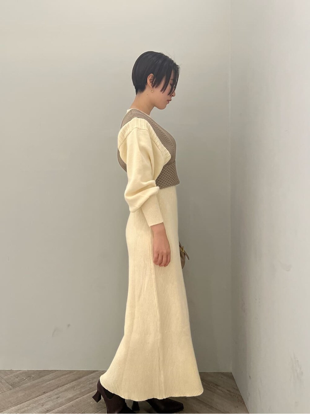 レッド系のブーツ、ホワイト系のワンピース、ホワイト系のワンピースを着用したレディースの秋コーディネートの2枚目の写真