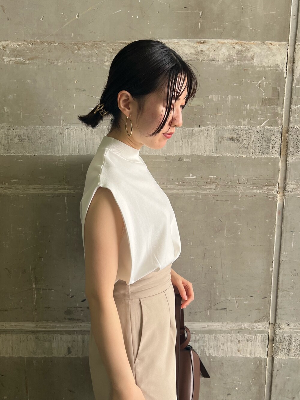 ブラウン系のサンダル、ベージュ系のハンドバッグ、ホワイト系のニット/セーターを着用したレディースの夏コーディネートの5枚目の写真