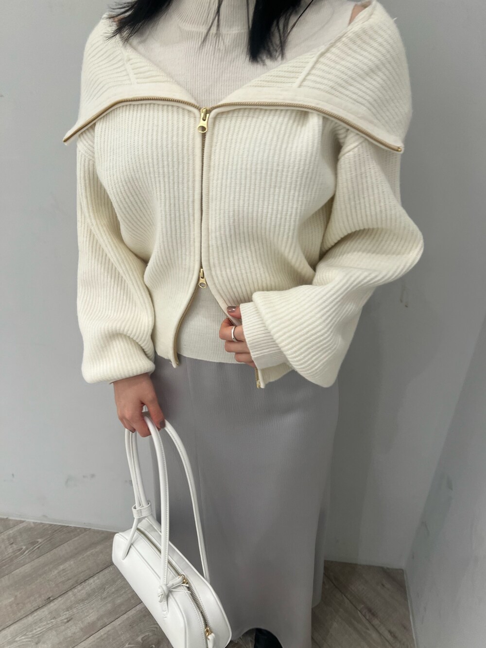 ホワイト系のニット/セーター、グレー系のスカートを着用したレディースの冬コーディネートの3枚目の写真