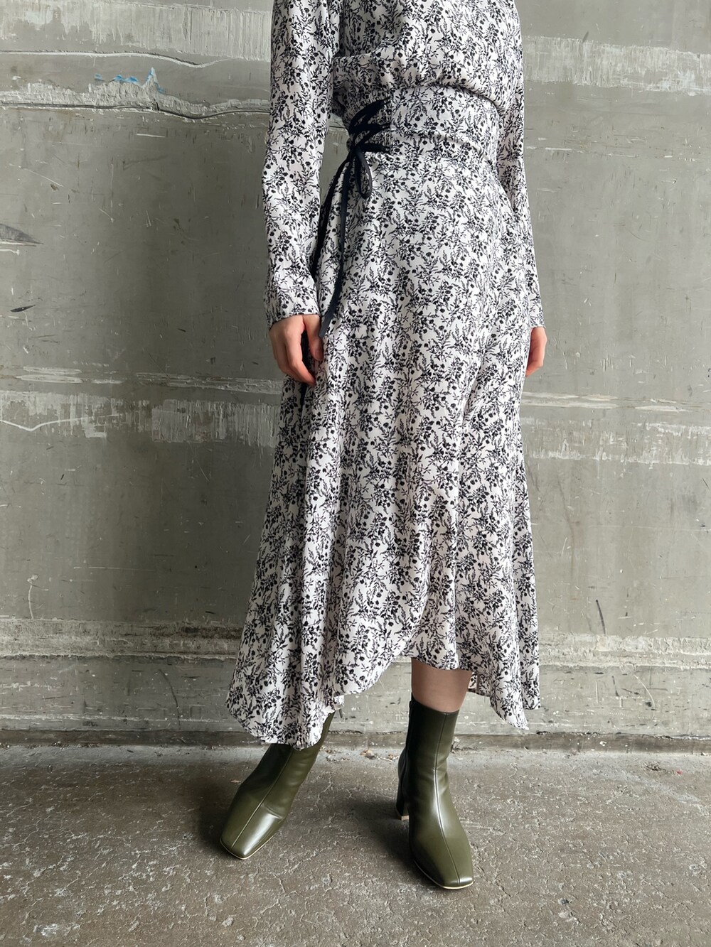 ベージュ系のブーツ、ブラック系のその他アウター、ホワイト系のワンピースを着用したレディースの冬コーディネートの8枚目の写真