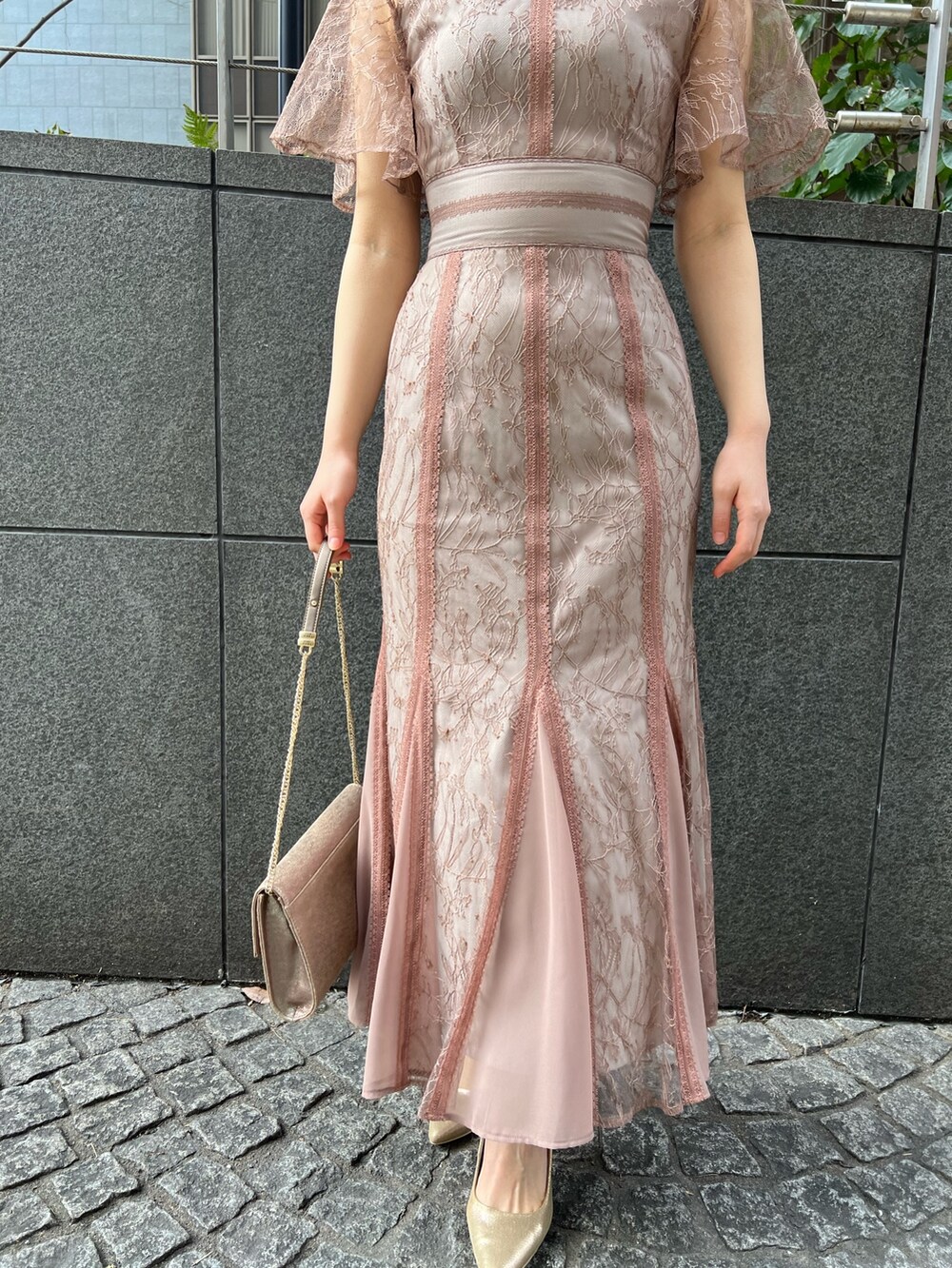 ゴールド系のハンドバッグ、ゴールド系のパンプス、ベージュ系のノーカラーコートを着用したレディースの冬コーディネートの10枚目の写真