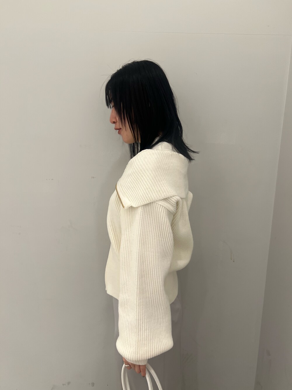 ホワイト系のニット/セーター、グレー系のスカートを着用したレディースの冬コーディネートの4枚目の写真