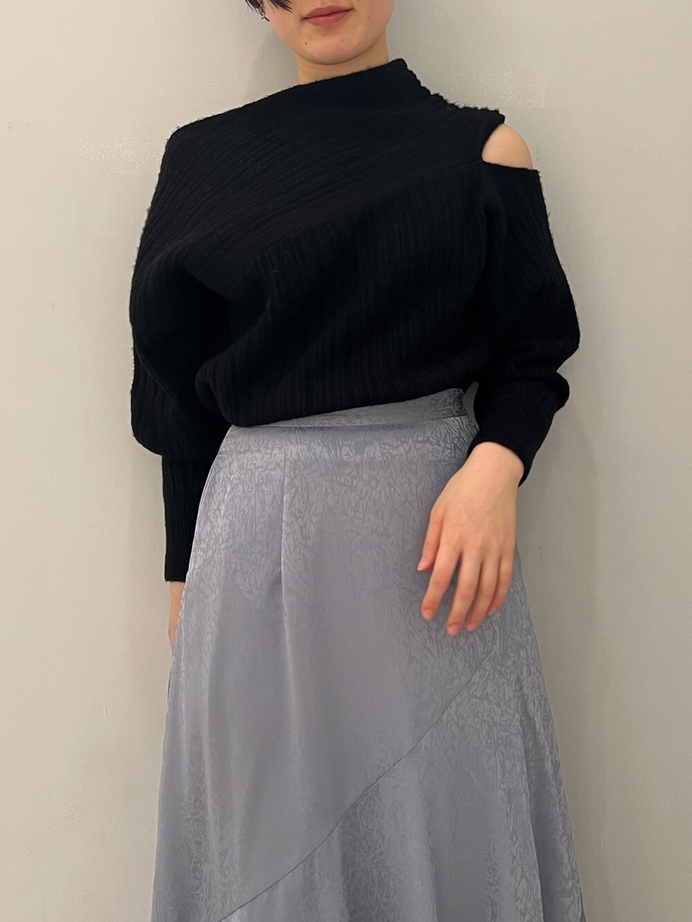 ブルー系のスカート、レッド系のブーツ、ブラック系のニット/セーターを着用したレディースの冬コーディネートの2枚目の写真