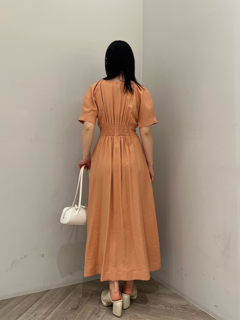 オレンジ系のワンピース、ホワイト系のサンダルを着用したレディースの春コーディネートの3枚目の写真