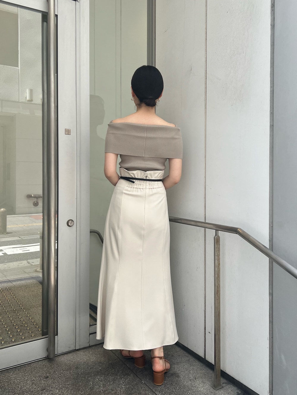 ホワイト系のショルダーバッグ、ホワイト系のスカート、ベージュ系のニット/セーターを着用したレディースの夏コーディネートの3枚目の写真