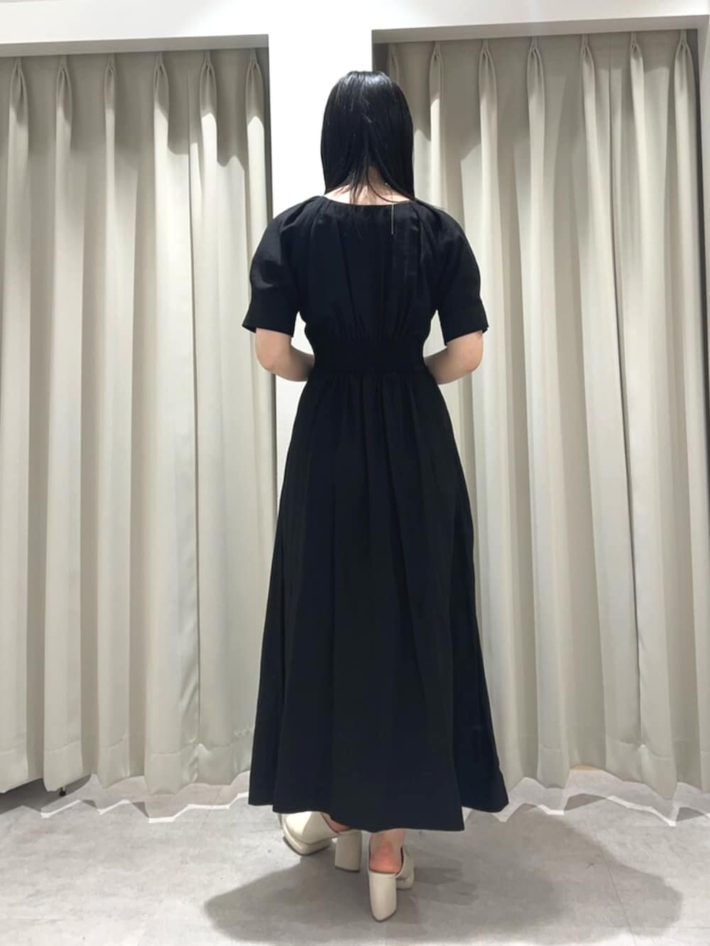 ホワイト系のサンダル、ブラック系のワンピースを着用したレディースの春コーディネートの3枚目の写真