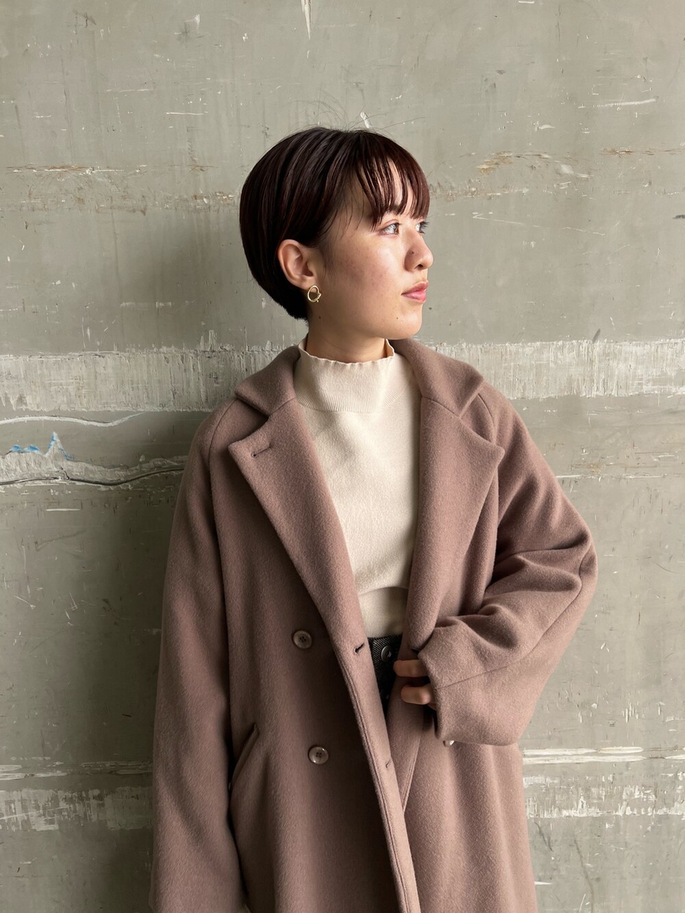 ブラウン系のスカート、ベージュ系のブーツ、ブラウン系のチェスターコートを着用したレディースの秋コーディネートの4枚目の写真