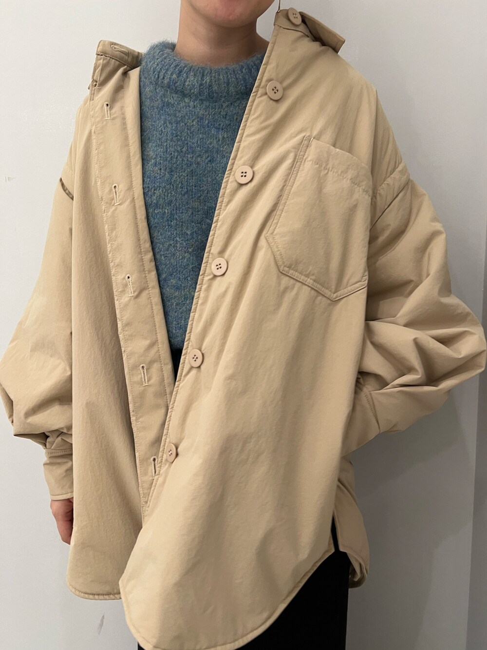 ベージュ系のブーツ、ブラック系のスカート、グリーン系のニット/セーターを着用したレディースの冬コーディネートの3枚目の写真