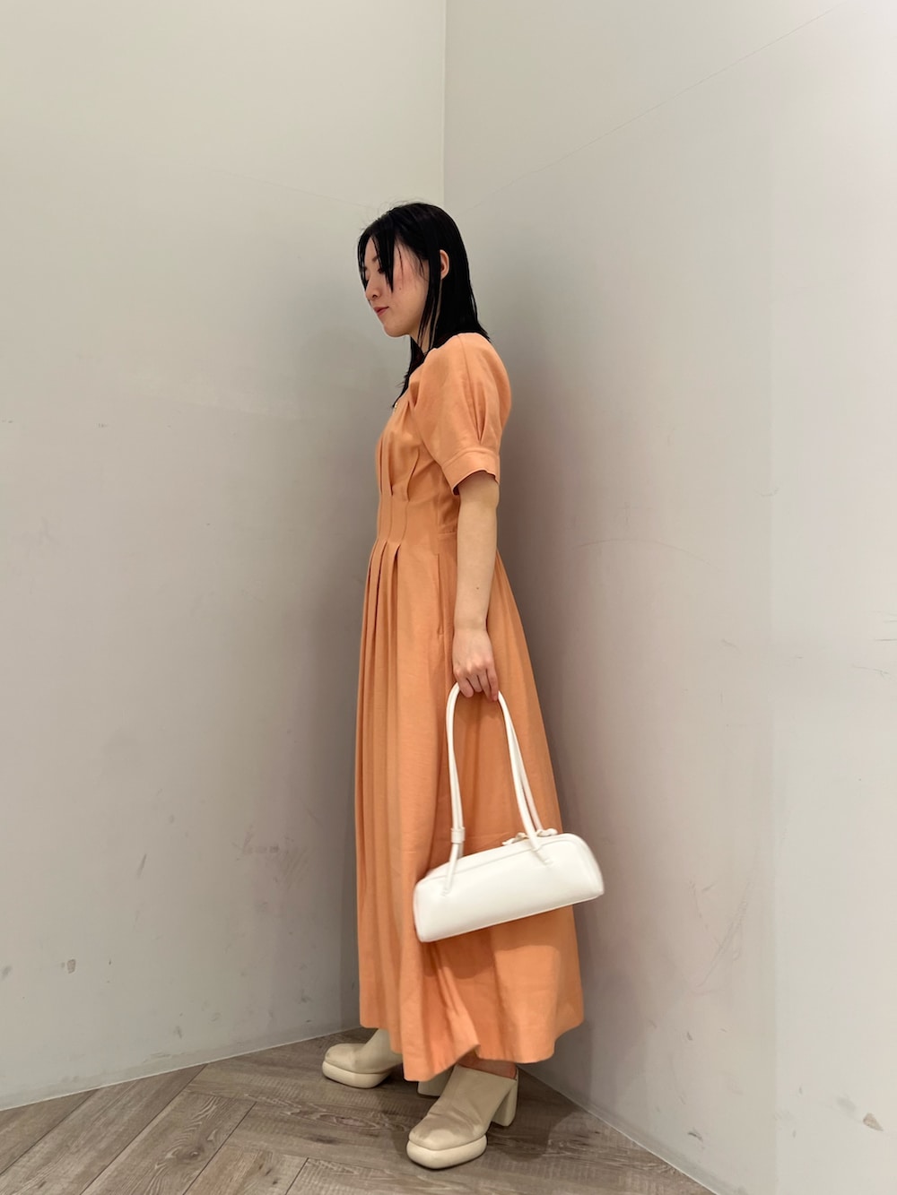 オレンジ系のワンピース、ホワイト系のサンダルを着用したレディースの春コーディネートの2枚目の写真