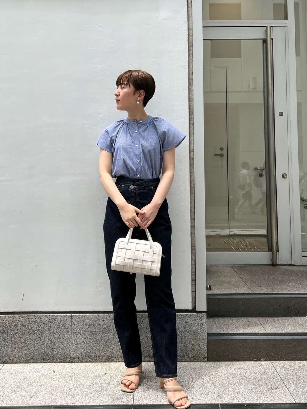 ベージュ系のサンダル、ホワイト系のショルダーバッグ、ブルー系のデニムパンツを着用したレディースの夏コーディネートの6枚目の写真
