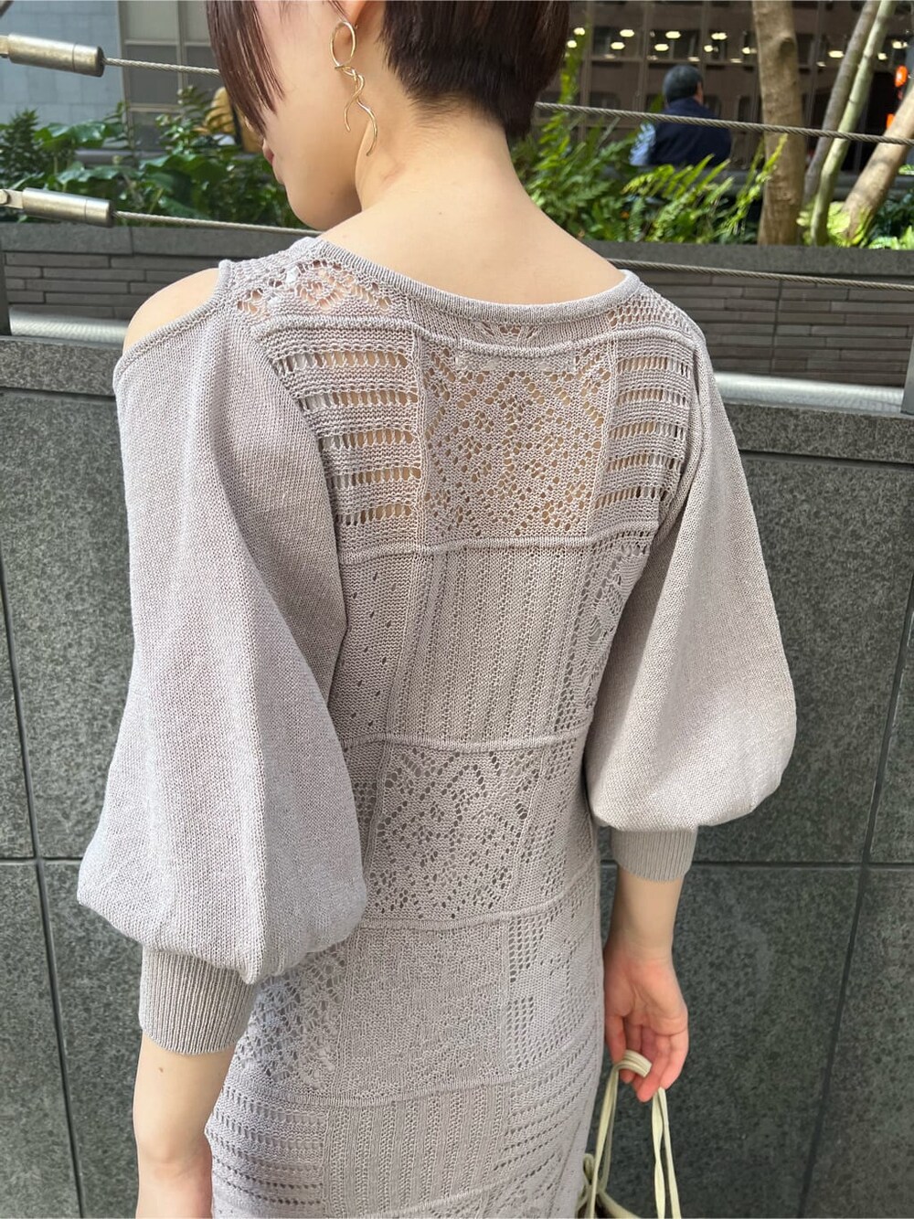 ホワイト系のハンドバッグ、グレー系のワンピース、その他のサンダルを着用したレディースの春コーディネートの5枚目の写真