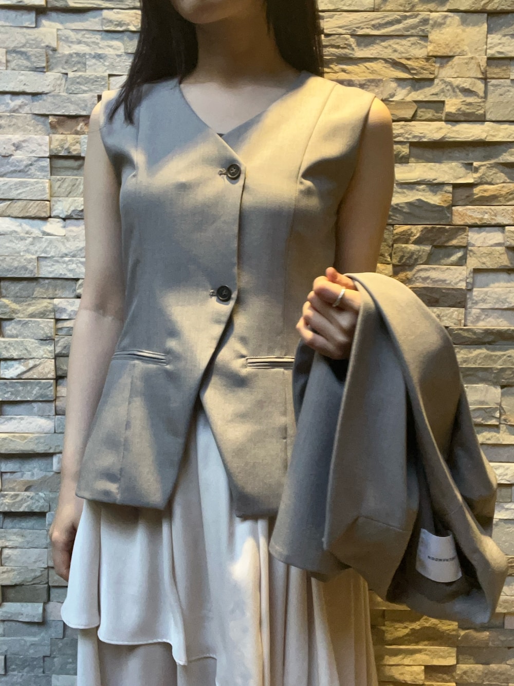 グレー系のワンピース、グレー系のテーラードジャケットを着用したレディースの冬コーディネートの4枚目の写真