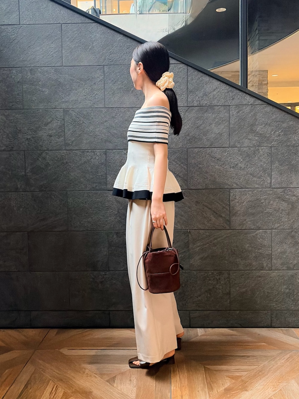 ホワイト系のニット/セーター、ホワイト系のその他パンツ、ブラック系のサンダルを着用したレディースの夏コーディネートの2枚目の写真