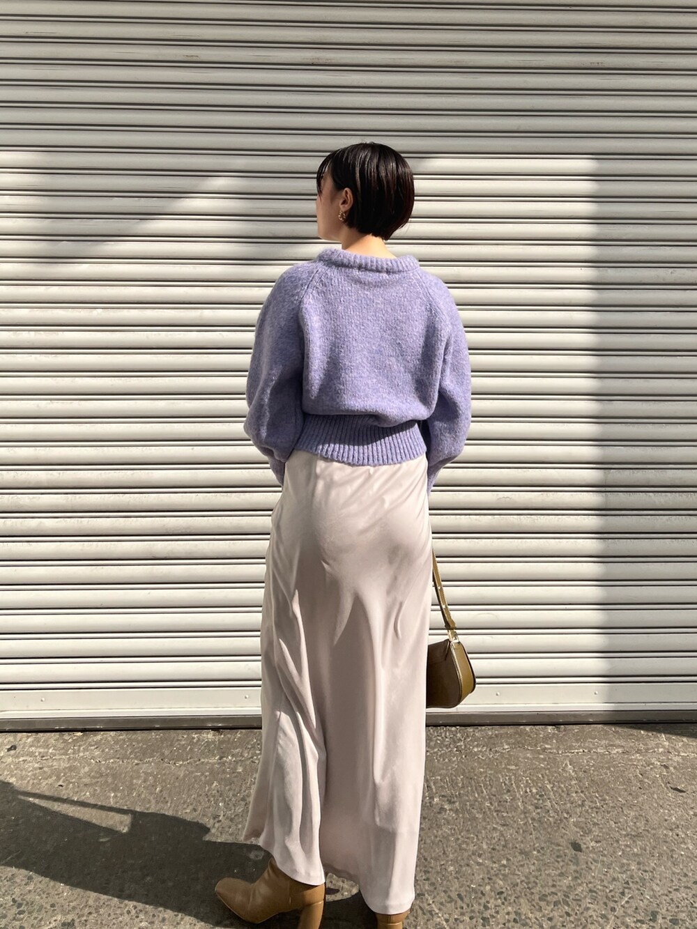 ブラウン系のショルダーバッグ、ベージュ系のブーツ、ベージュ系のダウンジャケット/コートを着用したレディースの冬コーディネートの4枚目の写真