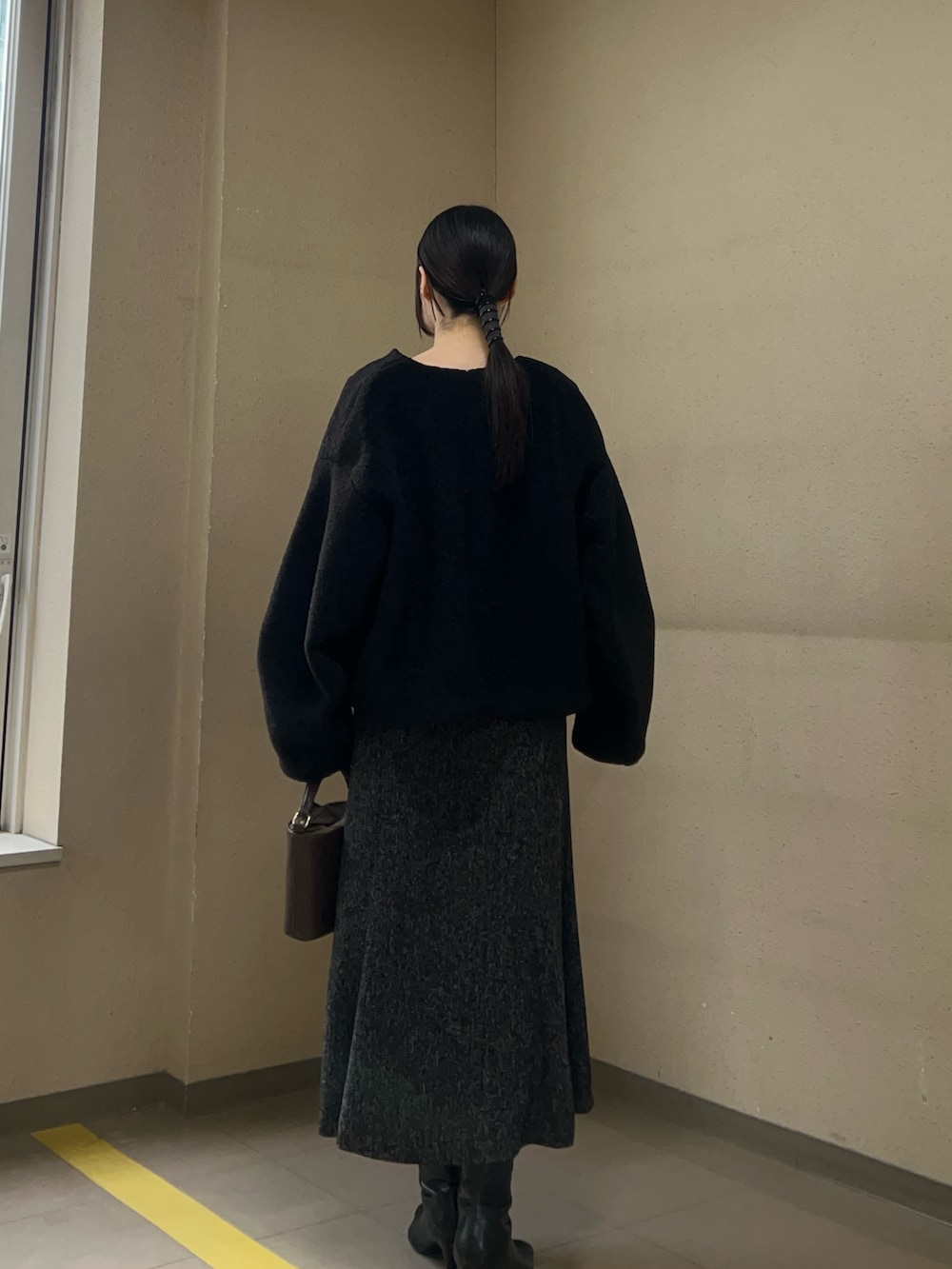 ブラック系のブルゾン、ホワイト系のニット/セーター、ブラック系のワンピースを着用したレディースの冬コーディネートの3枚目の写真