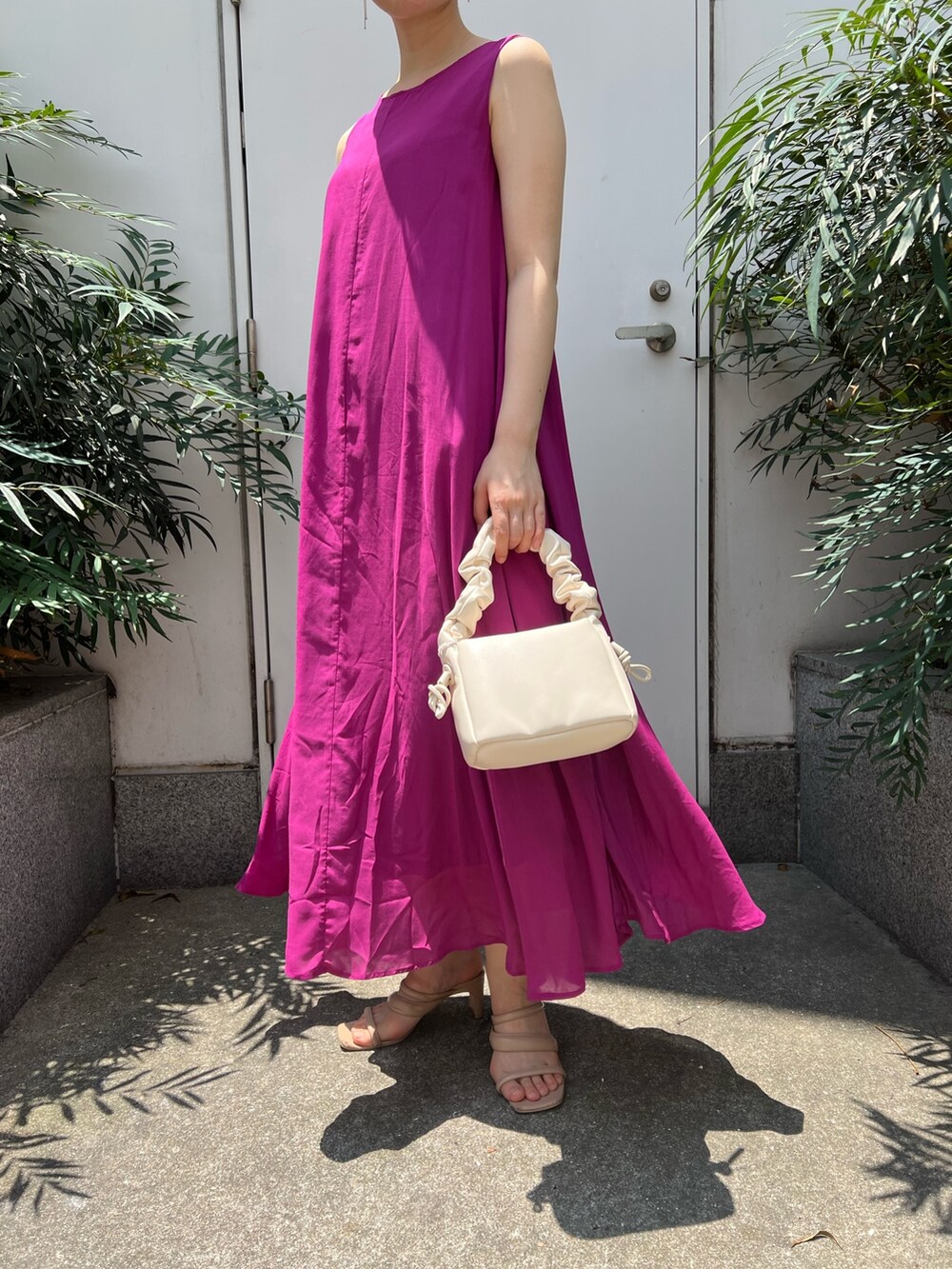 ベージュ系のサンダル、ホワイト系のハンドバッグ、パープル系のワンピースを着用したレディースの夏コーディネートの7枚目の写真