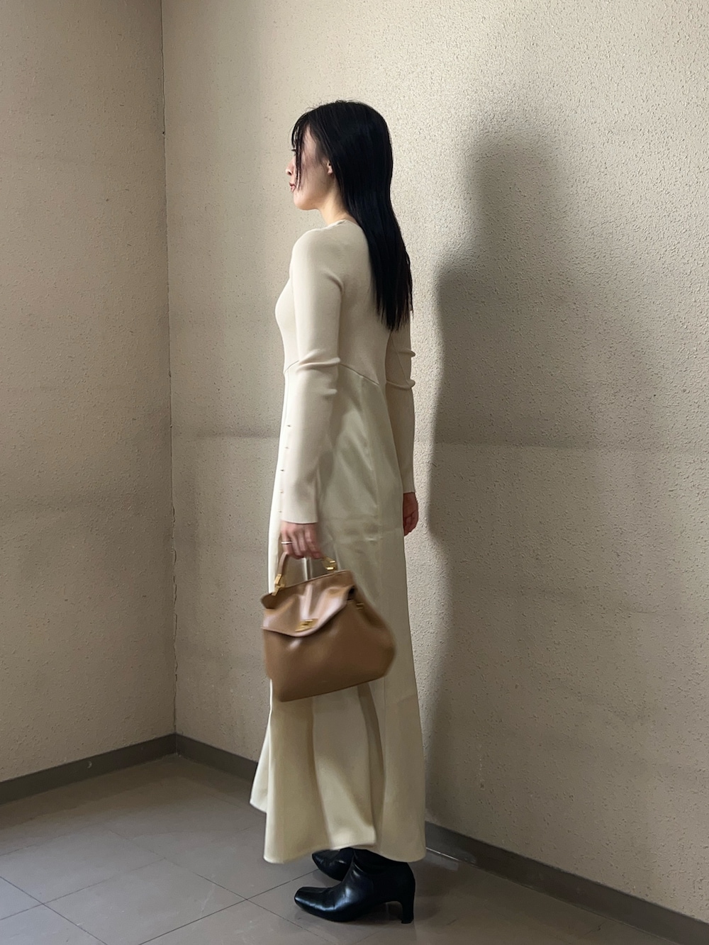 ホワイト系のワンピース、ブラック系のブーツを着用したレディースの秋コーディネートの2枚目の写真