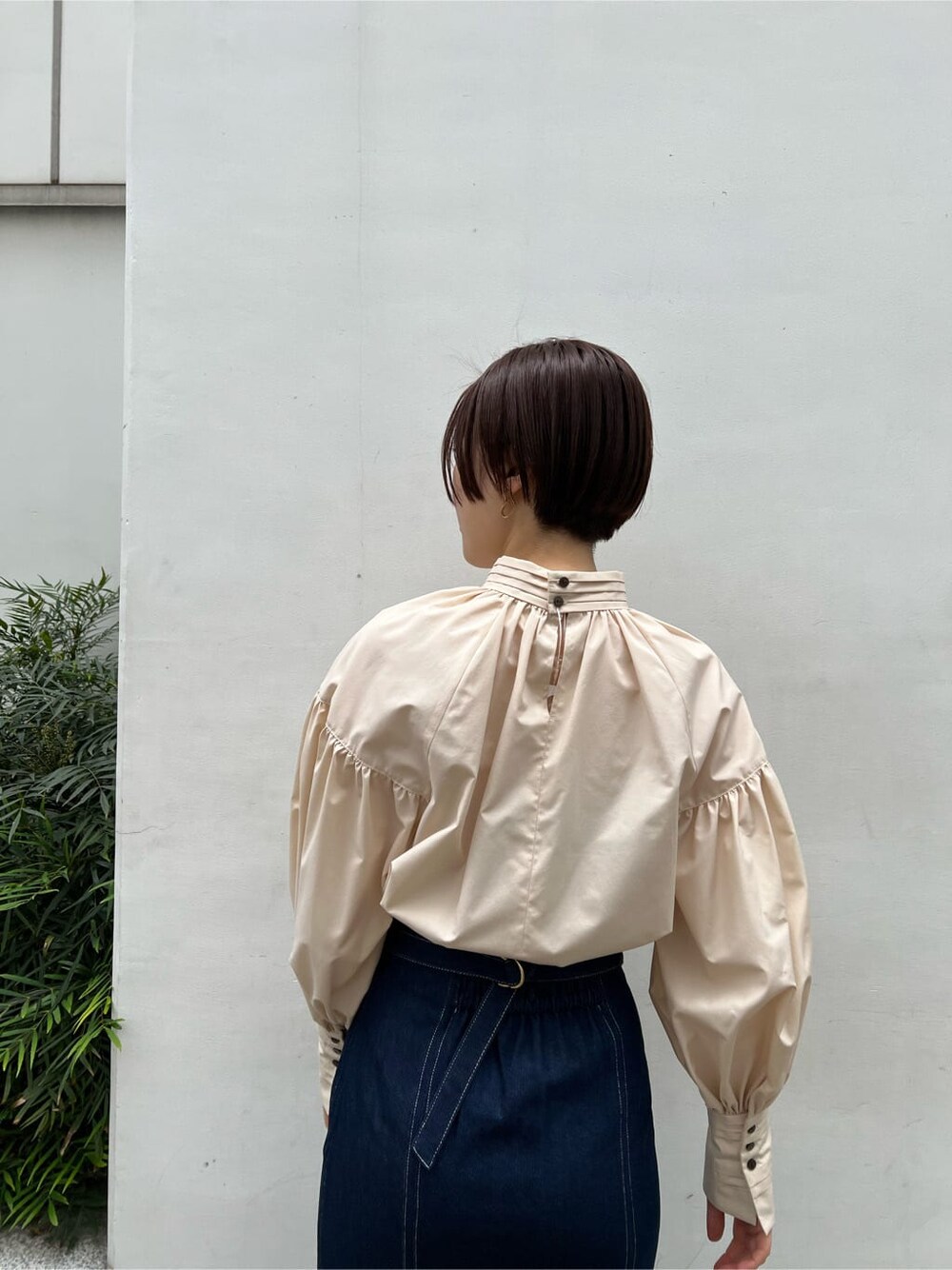 ベージュ系のシャツ/ブラウス、ベージュ系のブーツ、ブルー系のスカートを着用したレディースの春コーディネートの7枚目の写真