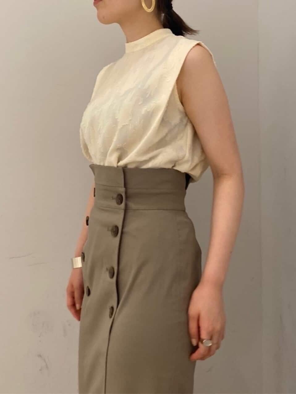 ブラック系のその他シューズ、ホワイト系のシャツ/ブラウス、グレー系のスカートを着用したレディースの夏コーディネートの5枚目の写真