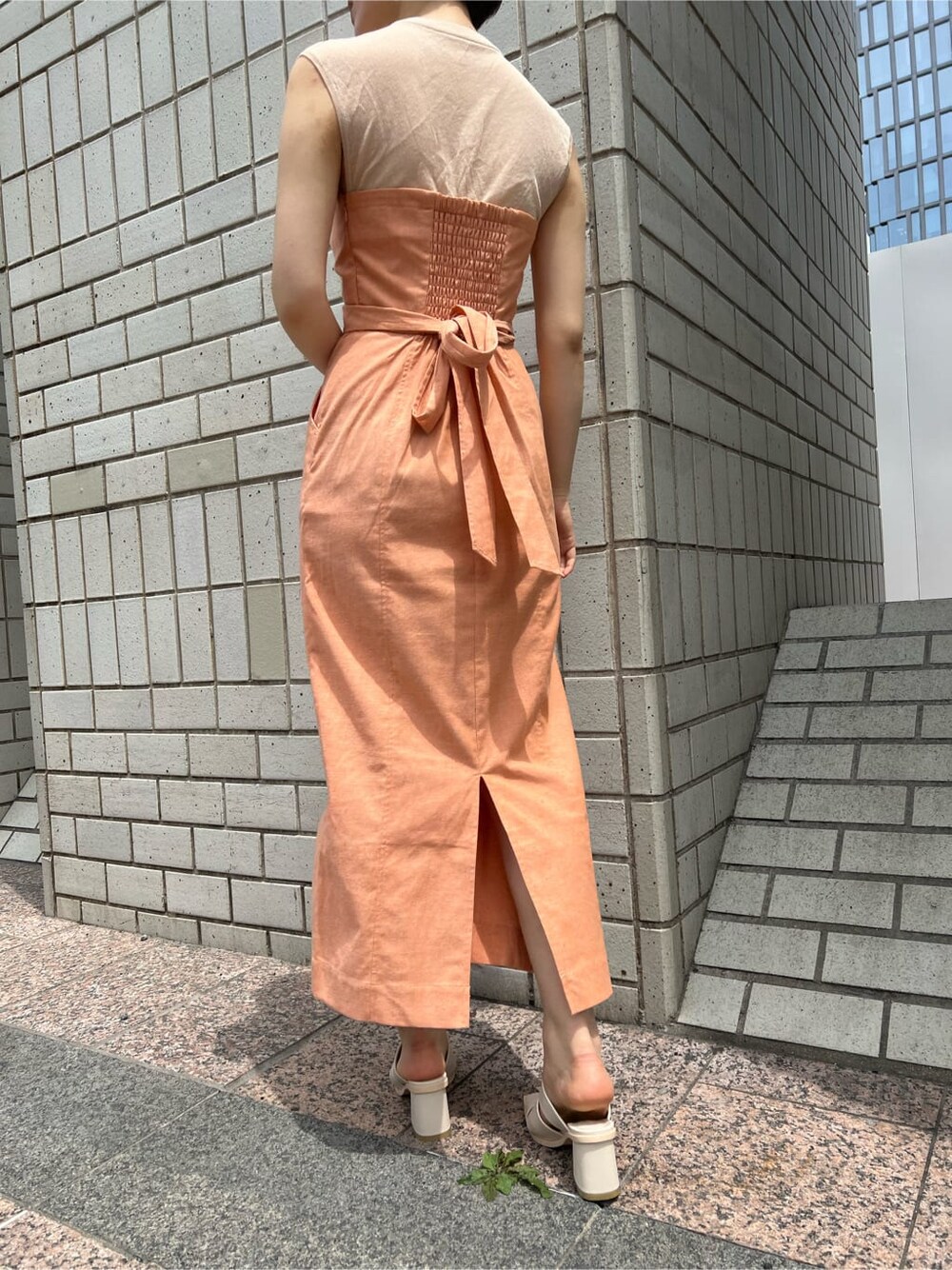 ホワイト系のブルゾン、オレンジ系のワンピース、ホワイト系のサンダルを着用したレディースの春コーディネートの6枚目の写真