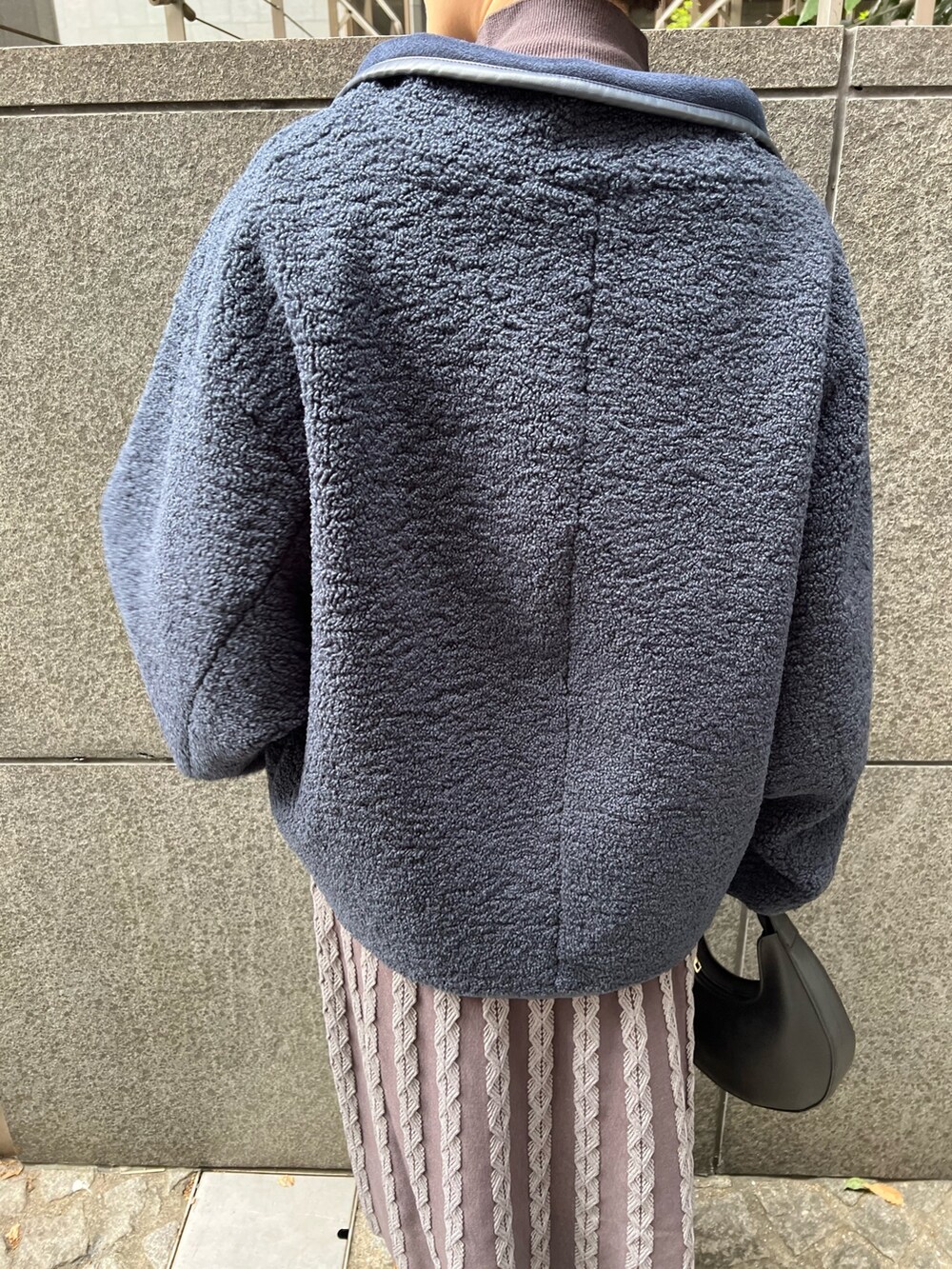 ベージュ系のブーツ、ブラック系のハンドバッグ、ブルー系のムートンコートを着用したレディースの秋コーディネートの6枚目の写真