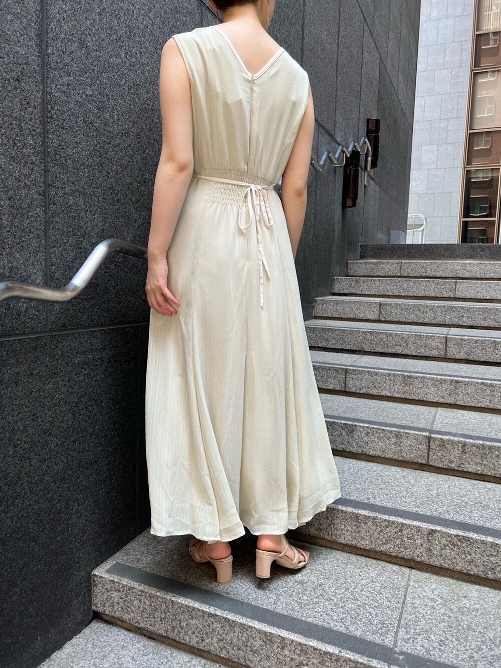 ベージュ系のサンダル、ホワイト系のハンドバッグ、グリーン系のワンピースを着用したレディースの夏コーディネートの4枚目の写真