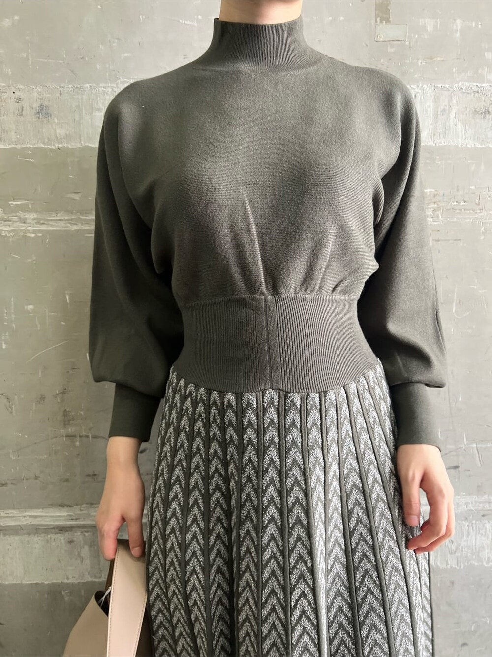 ベージュ系のブーツ、ベージュ系のハンドバッグ、ベージュ系のワンピースを着用したレディースの秋コーディネートの7枚目の写真